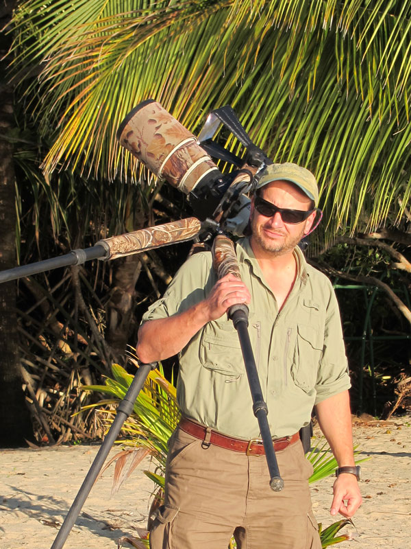 Portrait of Stan Tekiela on a beach holding a camera