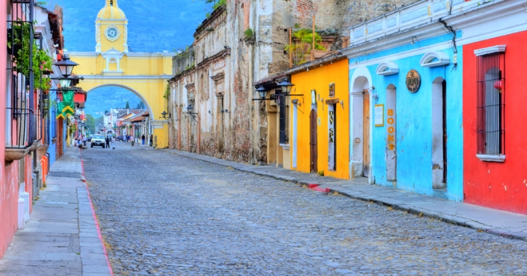 Street view of Antigua Guatemala's Santa Catalina Arch and colorful buildings