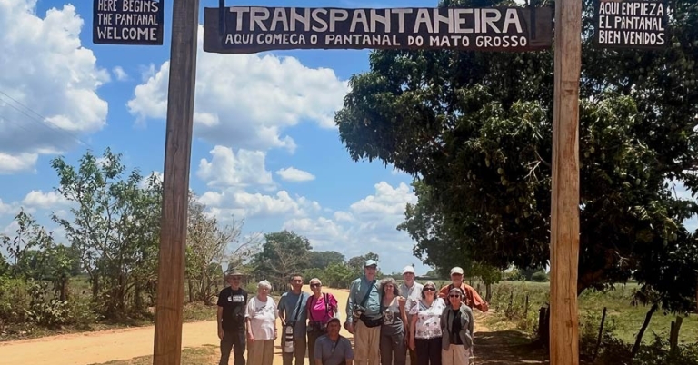 Group poses in front of a sign