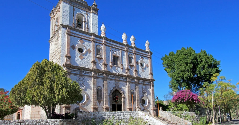 The exterior of a Spanish mission-style church with cut stone construction