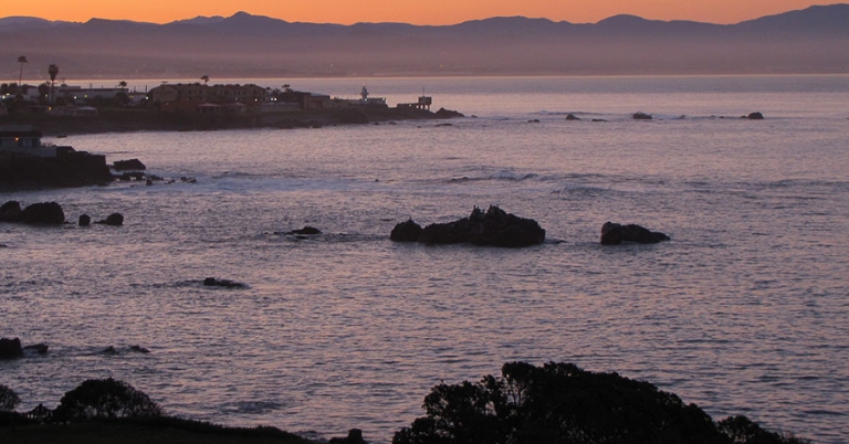 Ocean, shore, and horizon in the soft light of sunrise 