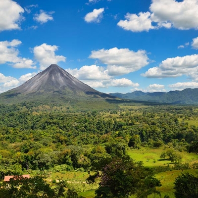 Conical volcano with forested landscape in the foreground.