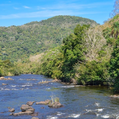 River with low, forested mountains in background