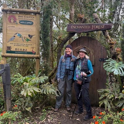 two travelers posing in from of the signs for Owl's Watch