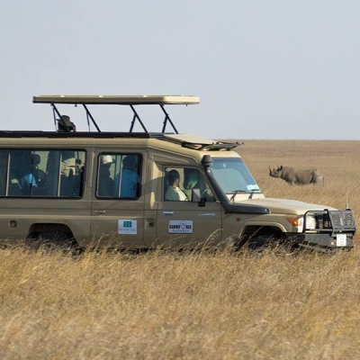 Safari jeep sitting in grass.