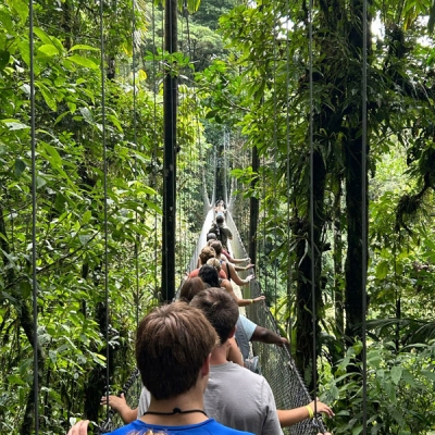 Students walking across a bridge in a single file line
