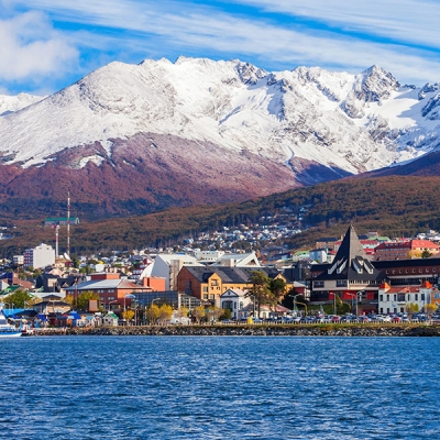 A town next to a body of water with a mountain backdrop