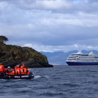 People in a raft looking at a big cruise boat