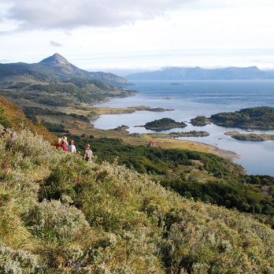 People walking by a mountain coastline