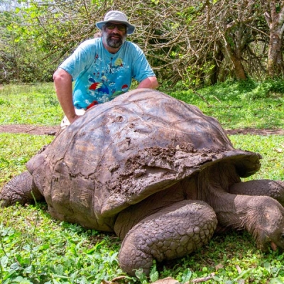 Eric Simon and a giant tortoise in the Galápagos Islands