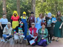 Group of people posed on a wooden deck in various Halloween costumes
