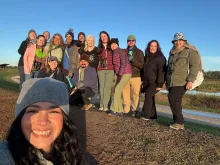 A group of people pose and smile at the camera